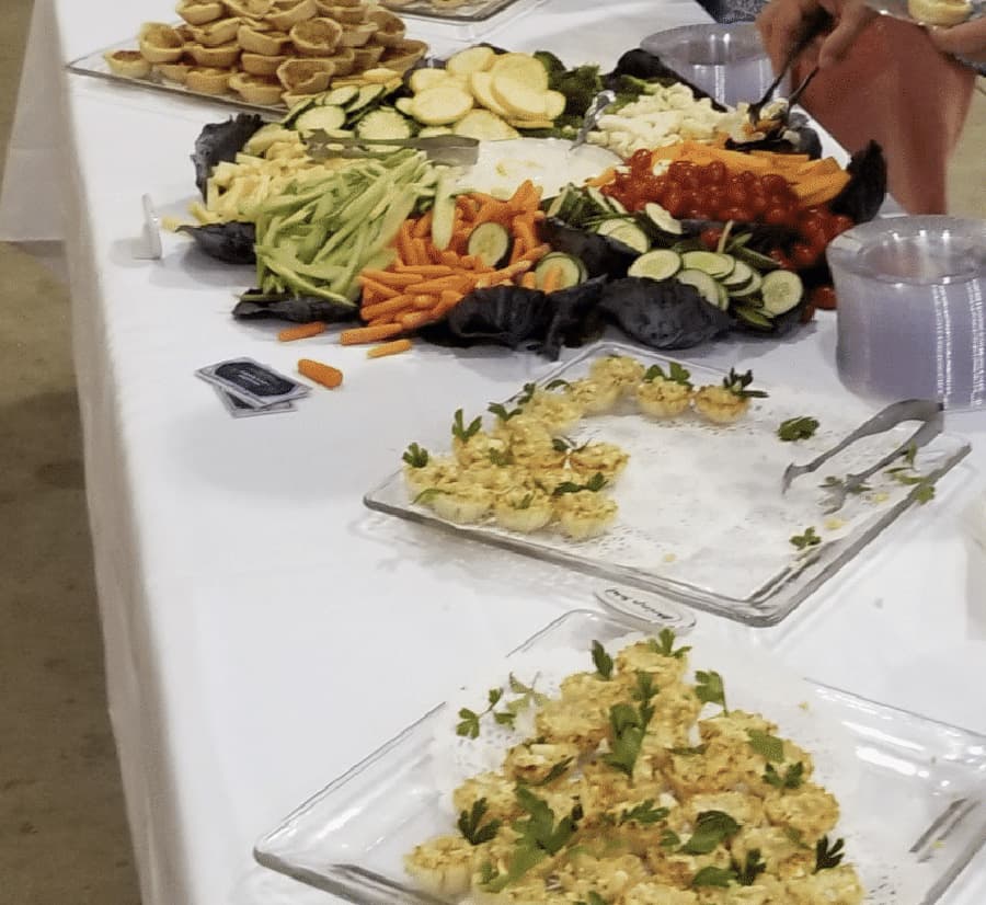 A buffet table with an assortment of fresh vegetables, fruits, and delicately arranged appetizers.